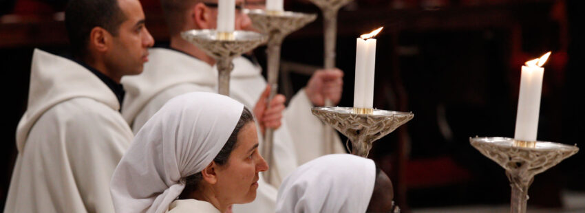 Religiosos y religiosas portando velas