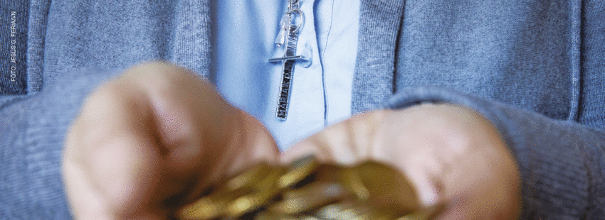 Religiosa con cruz sostiene monedas en la mano