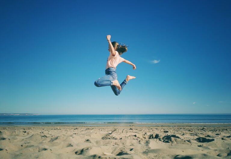 mujer saltando en la playa