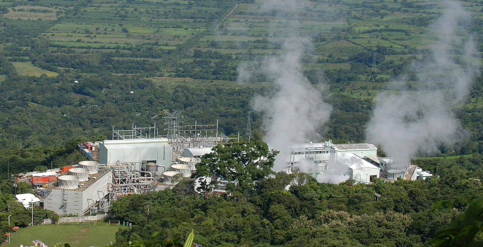 Una fábrica en medio del campo expulsando humo al medio amabiente