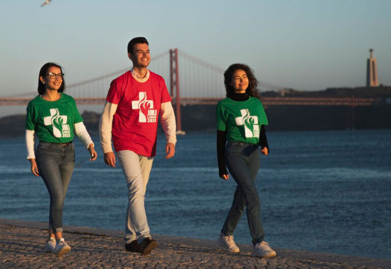 Tres jóvenes portugueses pasean a orillas del Tajo con su camiseta de la JMJ de Lisboa 2023