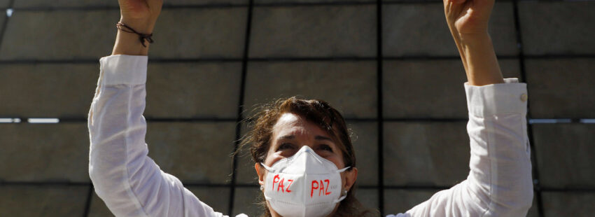 mujer mexicana con letrero de 'paz'