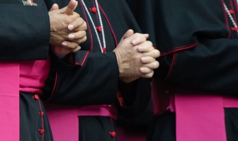 manos entrelazadas de obispos