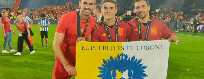 Gavi, Fabián Ruiz y Jesús Navas, con la bandera de la coronación de Nuestra Señora de las