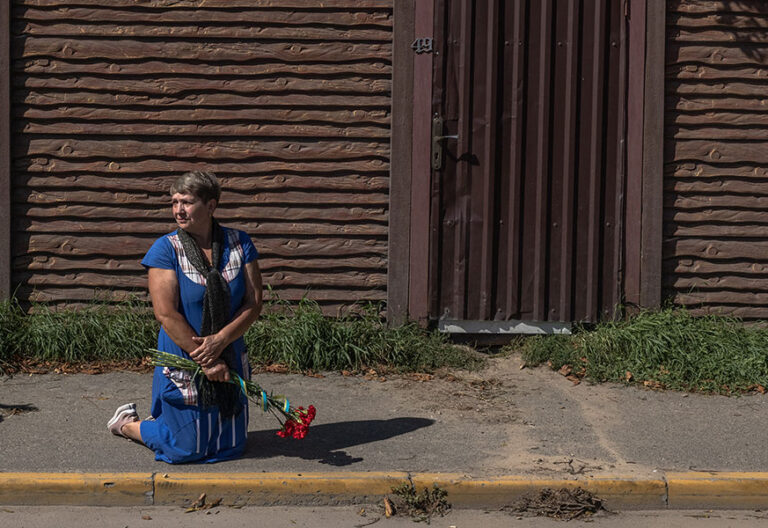 Persona de rodillas con flor. Rezar
