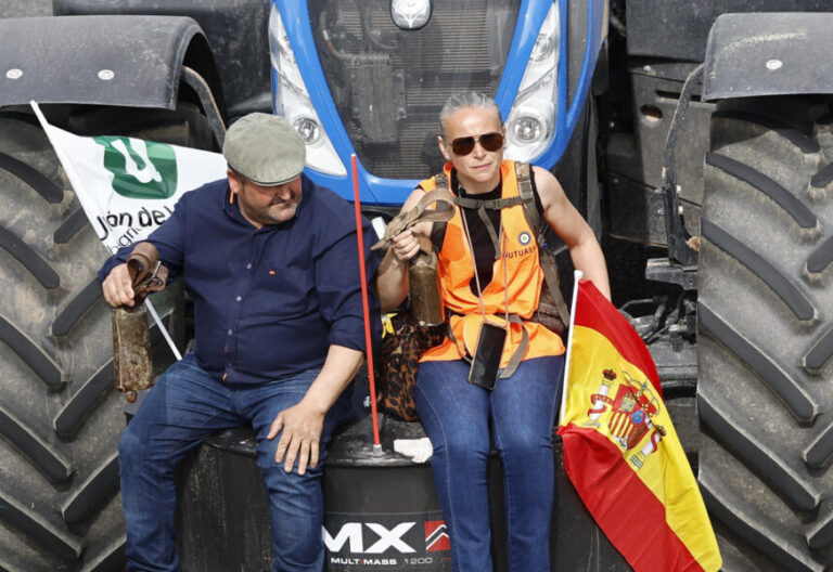 Dos agricultores protestan con su tractor
