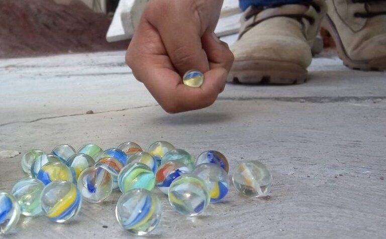 Niños jugando a las canicas