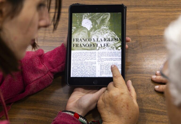 Dos mujeres de distintas generaciones observan en una tableta la noticia de la muerte de Franco recogida por 'Vida Nueva'
