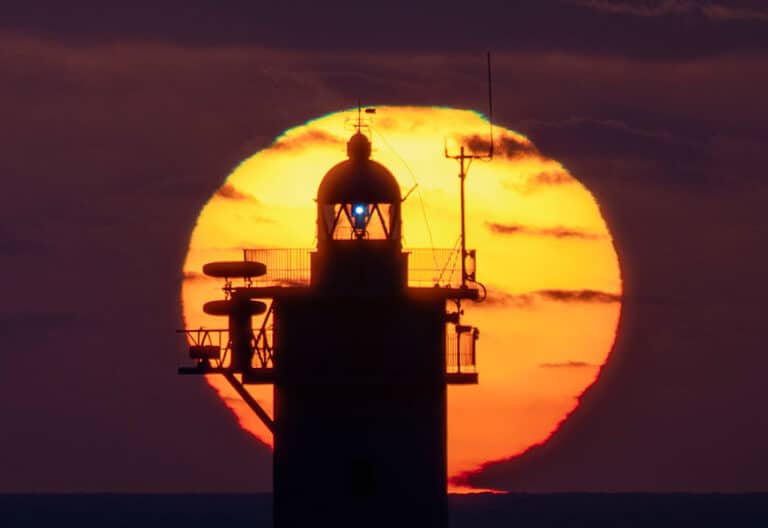 El sol sale junto al faro de Punta Gavioto en Puerto del Rosario (Fuerteventura)