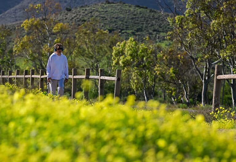 Mujer caminando sola por un paisaje natural de primavera. El molino de El Pozo de Los Frailes en el Parque Natural de Cabo de Gata-Níjar muestra.