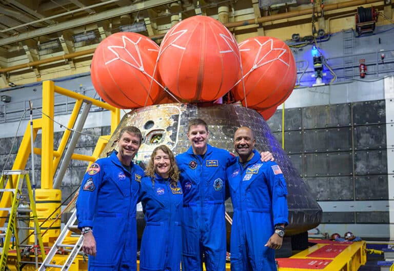 Los astronautas de la NASA Reid Wiseman, comandante (izquierda), Christina Koch, especialista de misión; el astronauta de la CSA (Agencia Espacial Canadiense), Jeremy Hansen, especialista de misión; y el astronauta de la NASA Victor Glover, piloto de Artemis II (derecha), posan para una foto grupal después de observar la nave espacial Orion en la cubierta de pozo del USS John P. Murtha, el sábado 11 de abril de 2026, en el Océano Pacífico frente a la costa de California.