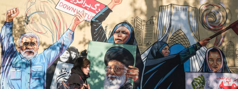 Una mujer pasa frente a un mural a favor de la República Islámica en Teherán. Foto: EFE