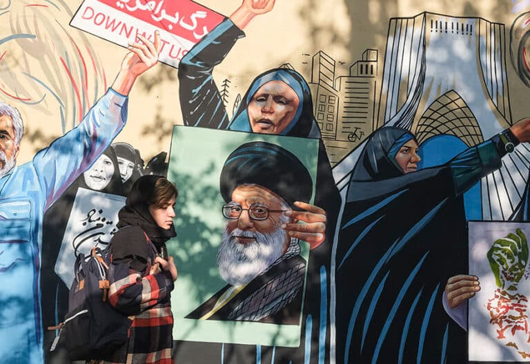 Una mujer pasa frente a un mural a favor de la República Islámica en Teherán. Foto: EFE