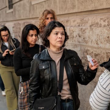 Fila de personas extranjeras para solicitar la regularización.