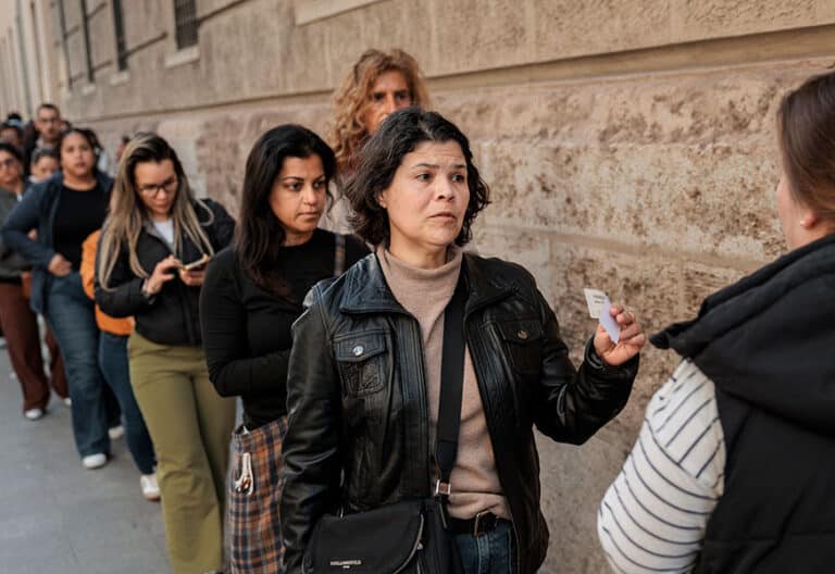 Fila de personas extranjeras para solicitar la regularización.