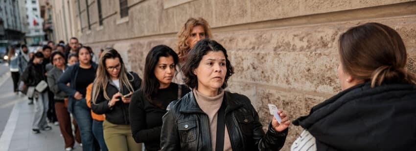 Fila de personas extranjeras para solicitar la regularización.