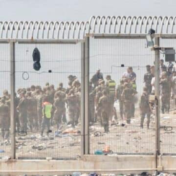 Policías de Marruecos retienen a migrantes en la frontera con Ceuta. Foto: Efe