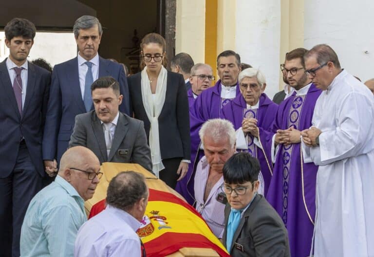 El obispo de Huelva, el esposo y los hijos de Fátima Báñez, tras el funeral de la ex ministra.